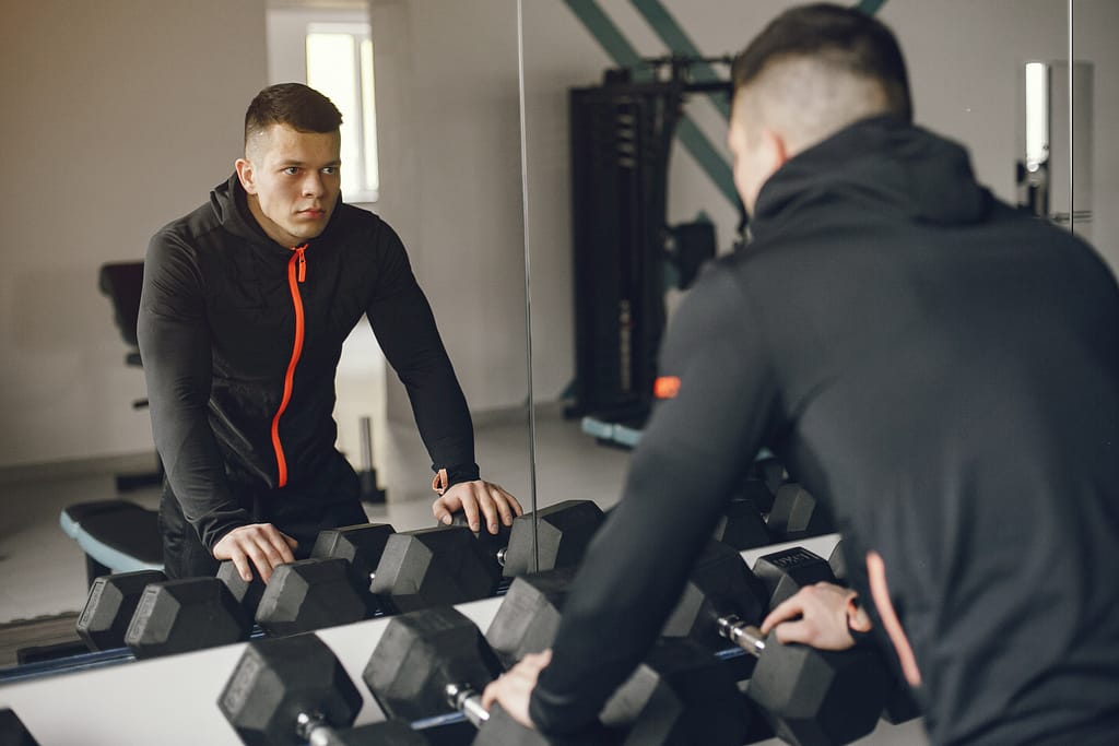 Focused young man training in the gym, reflecting on his journey to become a personal trainer in Canada.