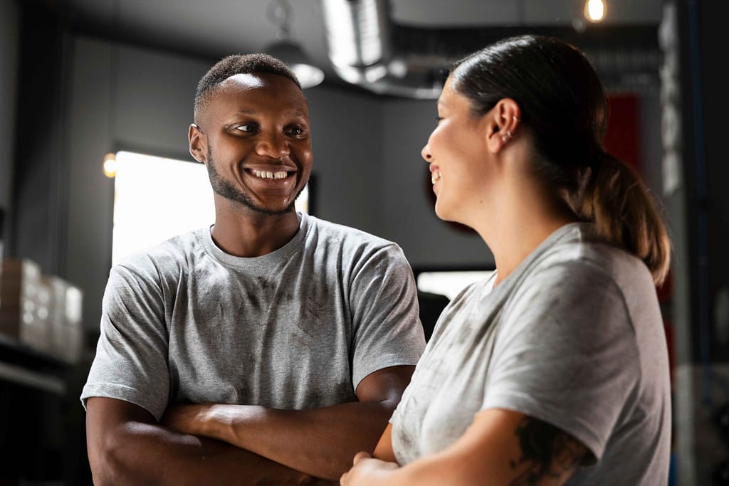 Personal trainers happy sharing insights in a bright training space.