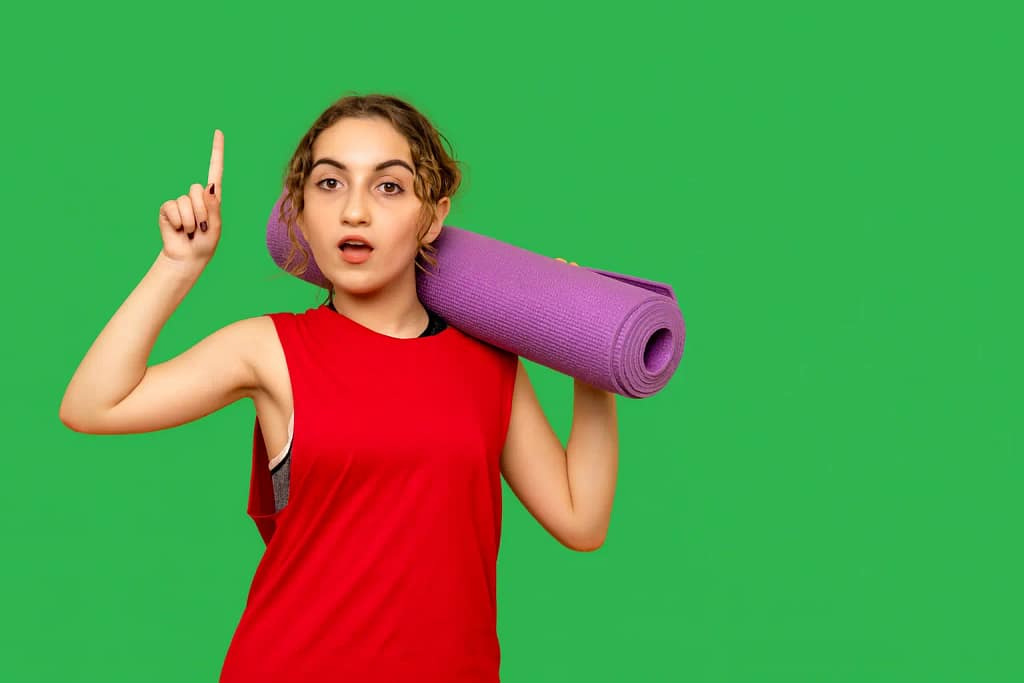 Yoga for beginners concept with a woman holding a purple yoga mat on her shoulder against a green background with the text Yoga for Beginners Your Essential Guide for 2026.